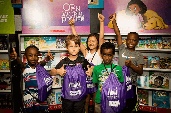 5 kids at a book fair holding backpacks with their thumbs up 5 kids at a book fair holding backpacks with their thumbs up